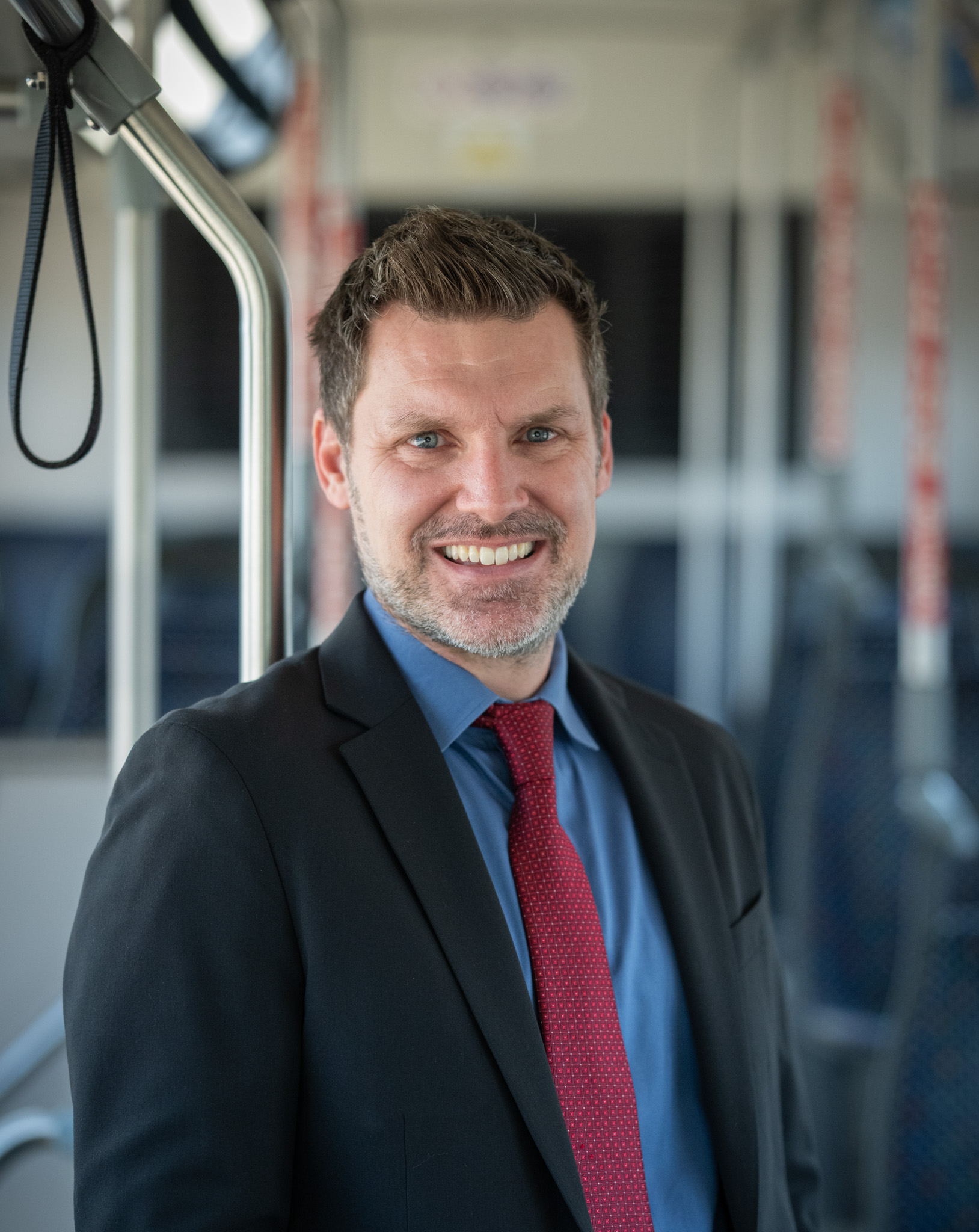 Headshot of Austin Frith, Vice President of Planning and Development, on a DCTA Connect Bus