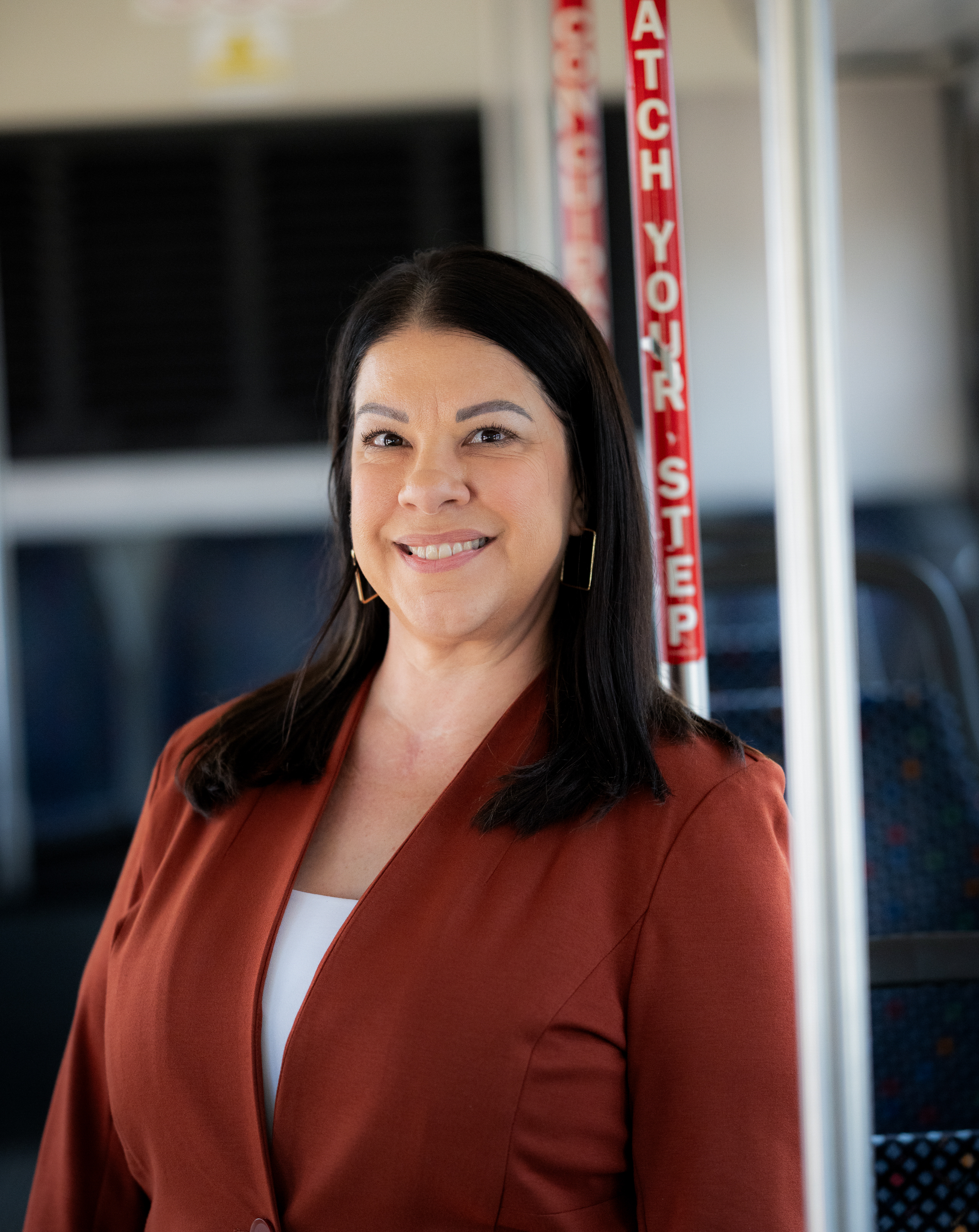 Headshot of Jackie Bronson, Vice President of Engagment & Administration, on a DCTA Connect Bus