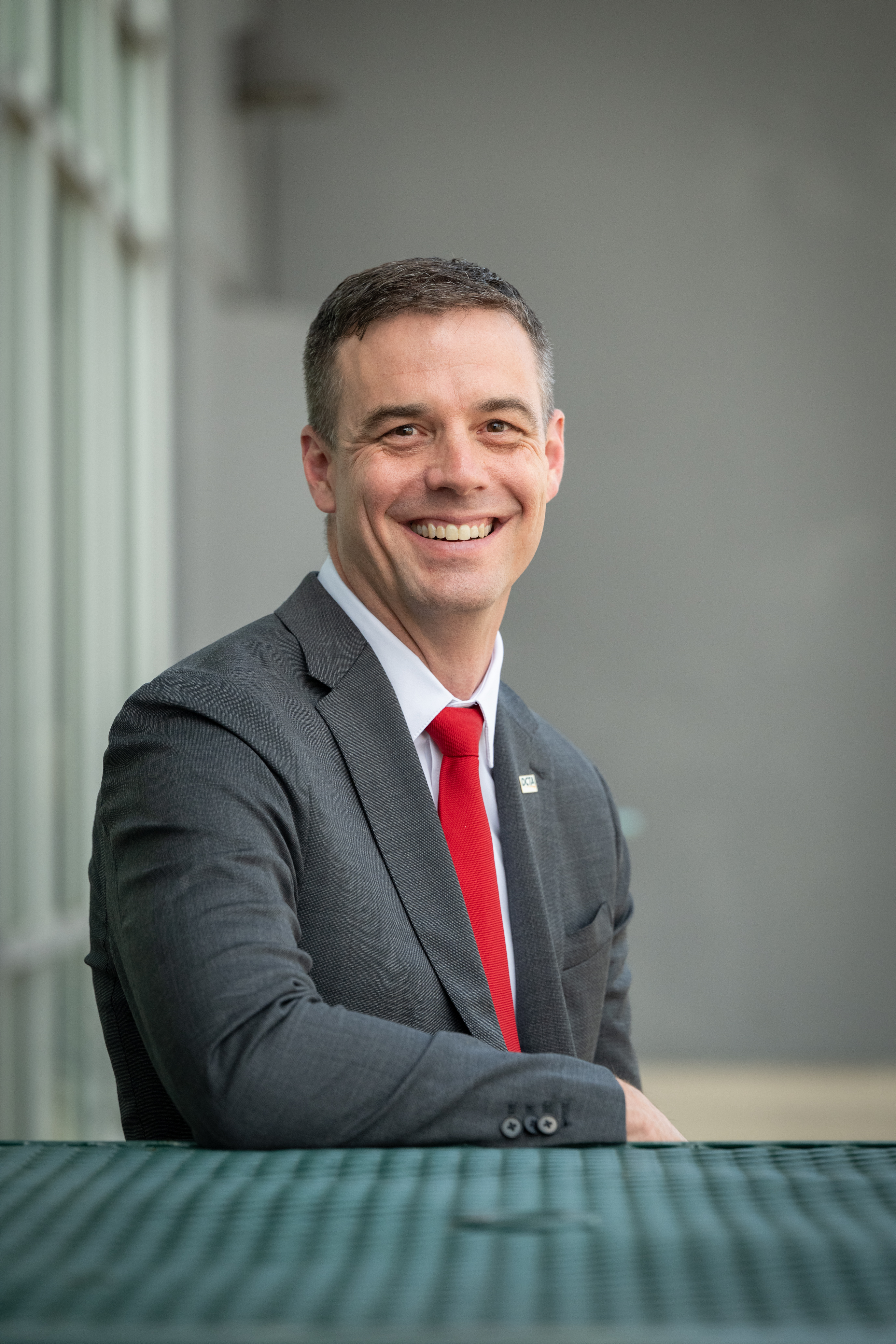 Headshot of Paul Cristina, President and CEO, sitting outside at the DCTA Bus Operations & Maintenance facility.