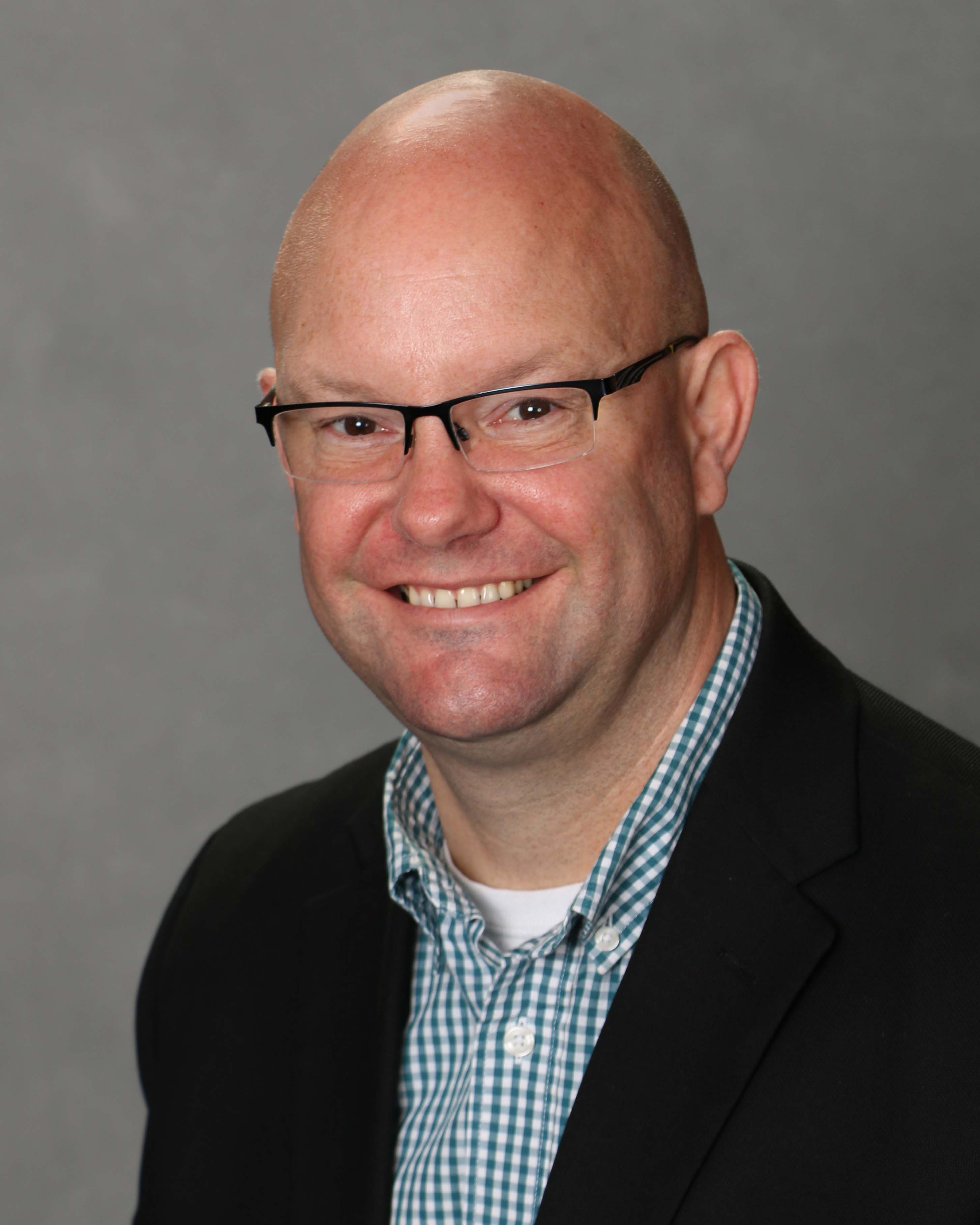 Headshot of Derick Sibley, Vice President of Finance, in front of a gray background