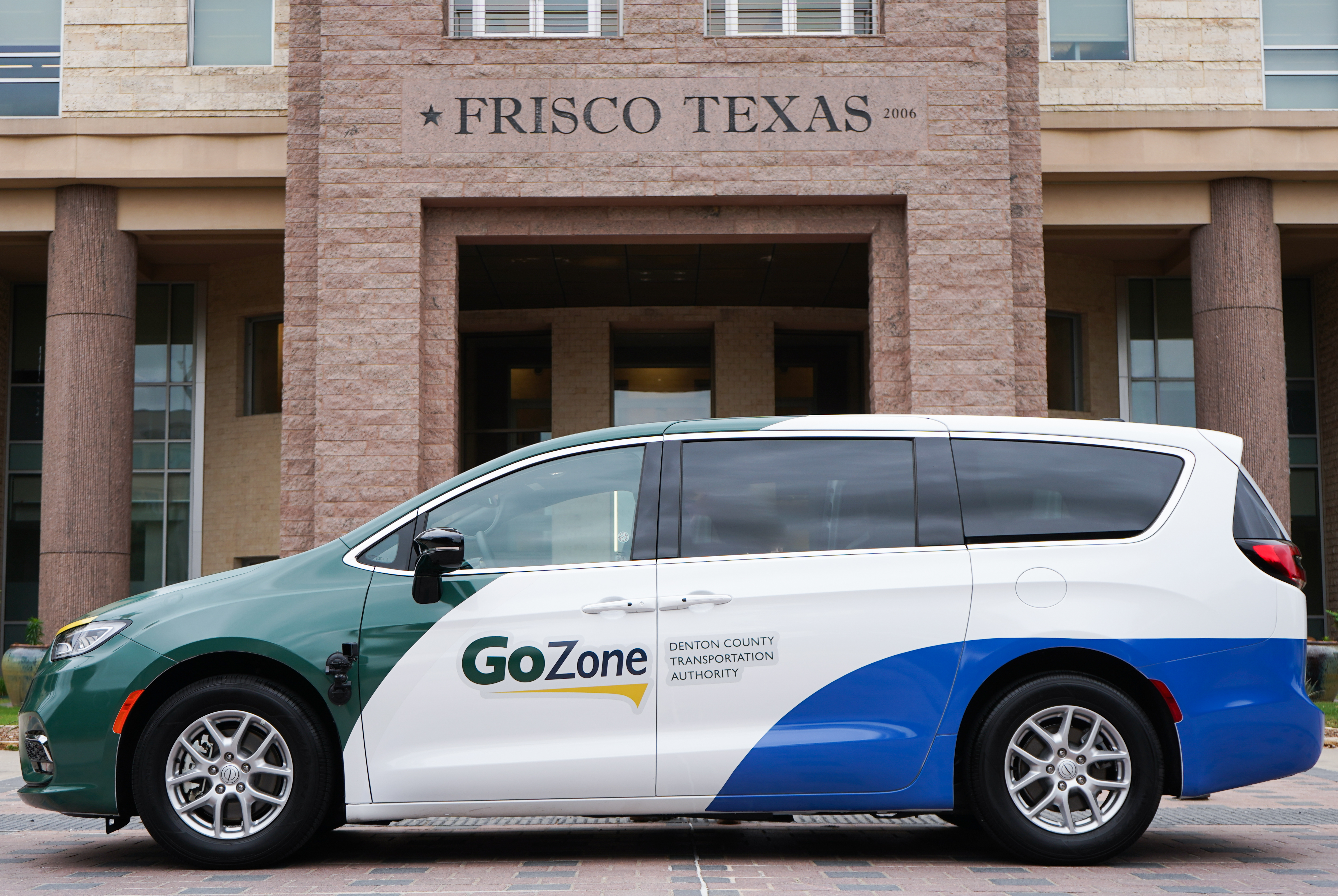 GoZone vehicle parked in front of Frisco City Hall under "Frisco Texas" text