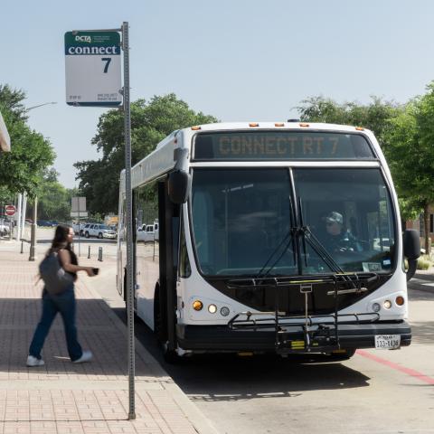 Image of a student boarding a Connect Route 7 bus at the DDTC bus stop